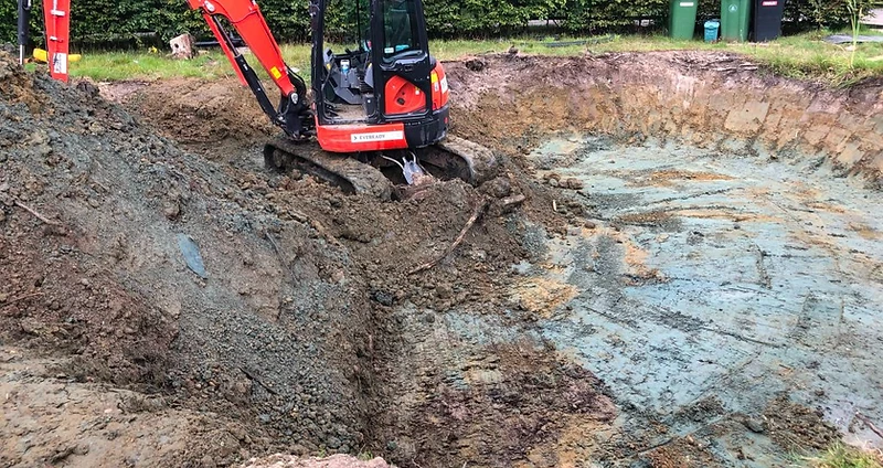 Mini excavator digging a pool excavation in a Surrey garden