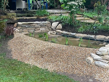 Ornamental pond with stone edging and established aquatic planting in Surrey