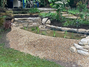 Ornamental pond with stone edging and established aquatic planting in Surrey