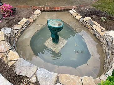 Water feature under construction with liner and stone coursing in Surrey