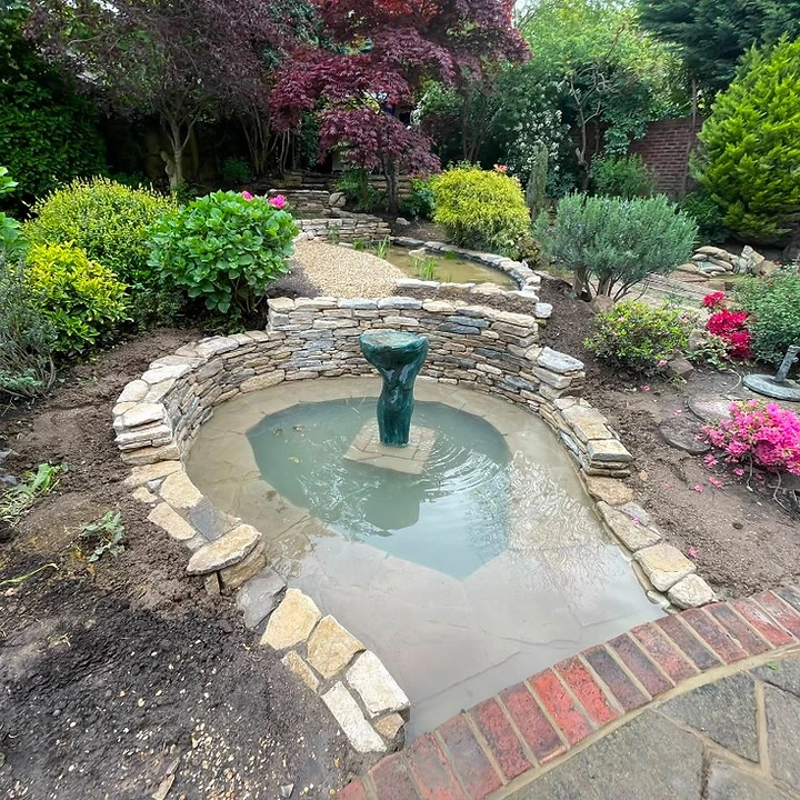 Garden water feature with stone surround in a completed Surrey garden
