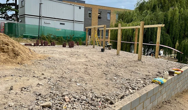 Groundworks in progress with drainage runs and compacted sub-base in Surrey