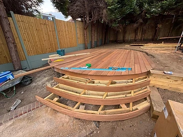 Circular wooden deck with boards laid and curved stair frame being built in Surrey