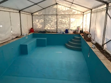 Small swimming pool with a blue liner and brick step entry, Surrey