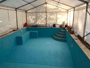 Completed small swimming pool with blue liner and brick steps in Surrey