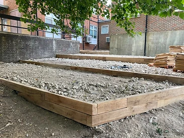 Timber steps terracing down a sloped garden in Surrey