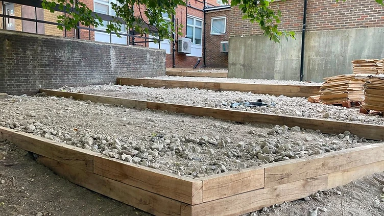 Timber steps terracing down a sloped garden in Woking