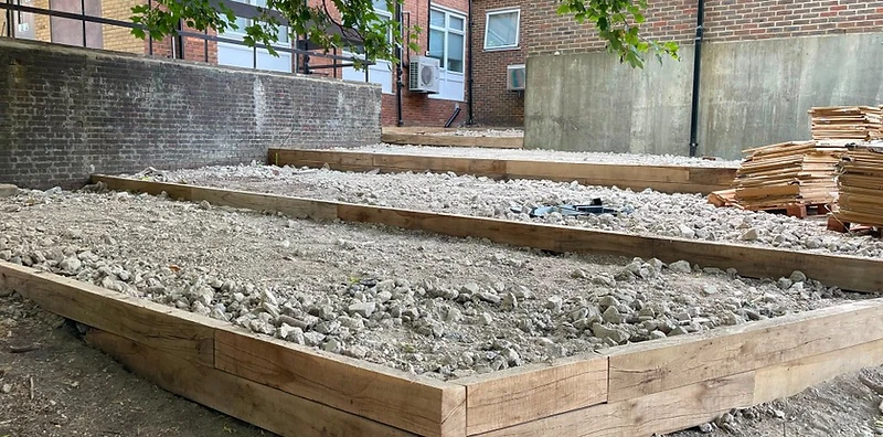 Timber steps terracing down a sloped garden in Surrey