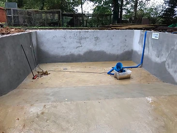 Rendered pool walls with inlet pipework and light fitting in Surrey