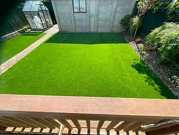 Newly turfed lawn viewed from a timber deck in a Surrey garden