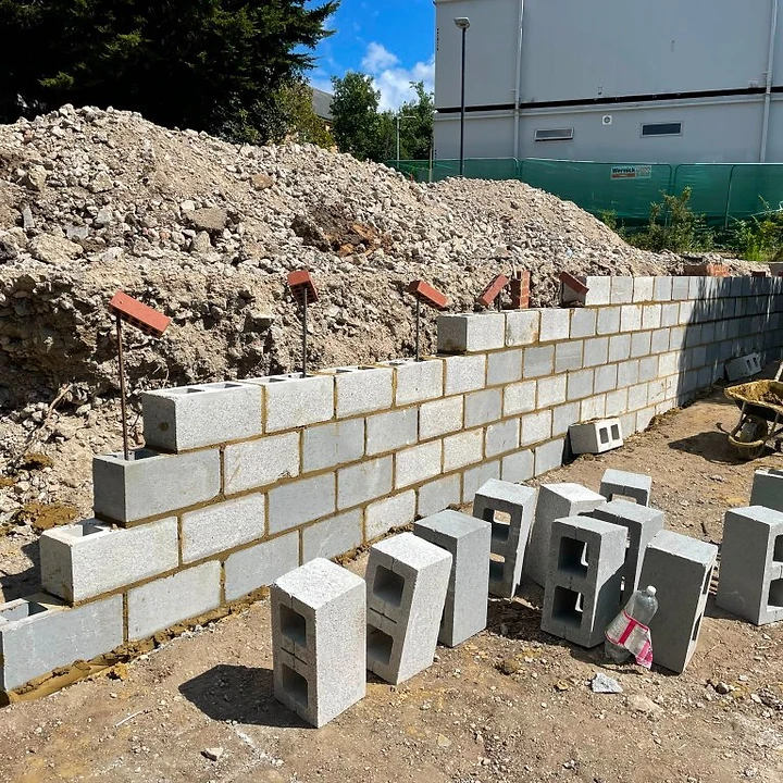Stone retaining wall in a Surrey garden with steps leading to a raised lawn