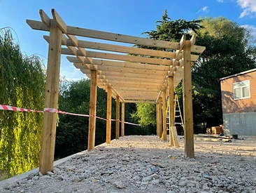 Timber pergola frame under construction with posts and cross-beams in Surrey