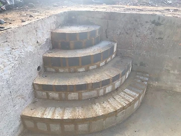 Curved brick steps formed inside a concrete pool shell, Surrey