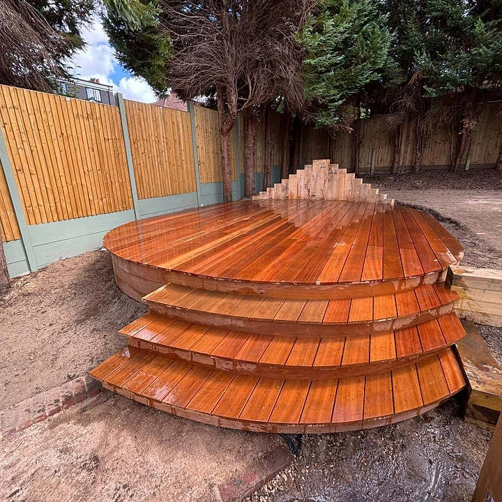 Circular timber decking under construction with stepped levels in a Surrey garden