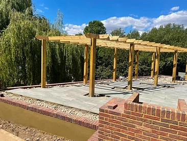 Completed timber pergola over porcelain paving with brick planters in Surrey