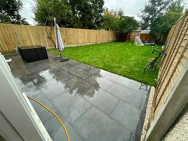 Grey porcelain patio with new turf and close-board fence in Surrey