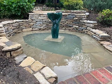 Bronze sculpture set in a drystone-walled pond, Surrey