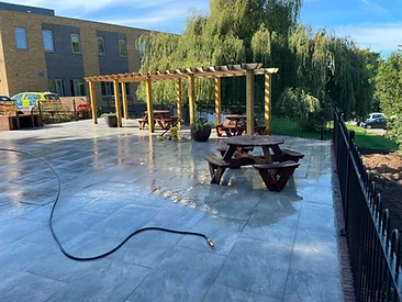 Grey porcelain paving meeting a timber decking section in a Surrey garden