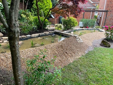 Stone water feature set in a mature garden border in Surrey