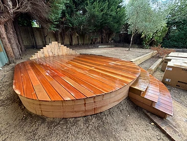 Completed circular garden deck with curved steps and vertical slat privacy screen in Surrey