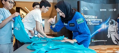 Astronaut signing t-shirts for young future astronauts