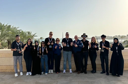 Instructor team posing outdoors by the waterfront