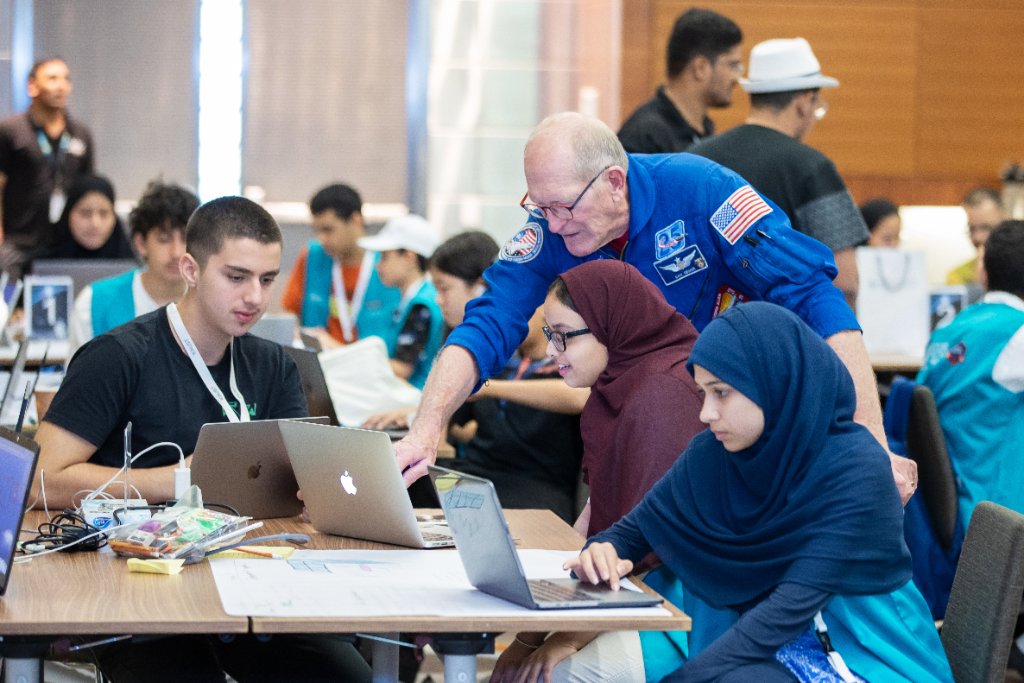 NASA astronaut mentoring students at a laptop during a SkillUp Global Academy programme
