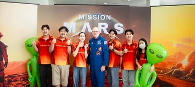 Students posing with inflatable aliens at the Mission Mars backdrop