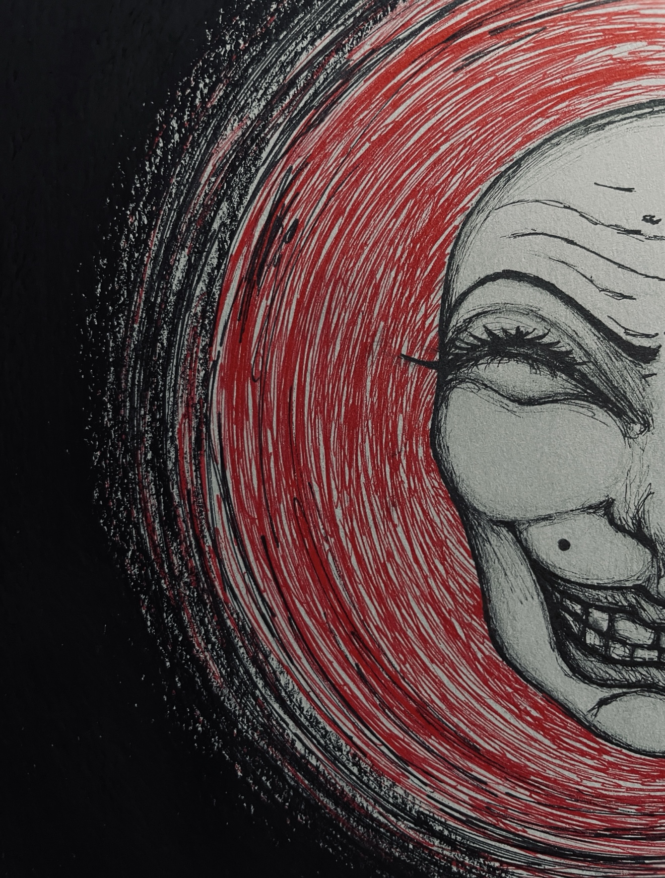 Ink drawing of a smiling face within red swirling lines