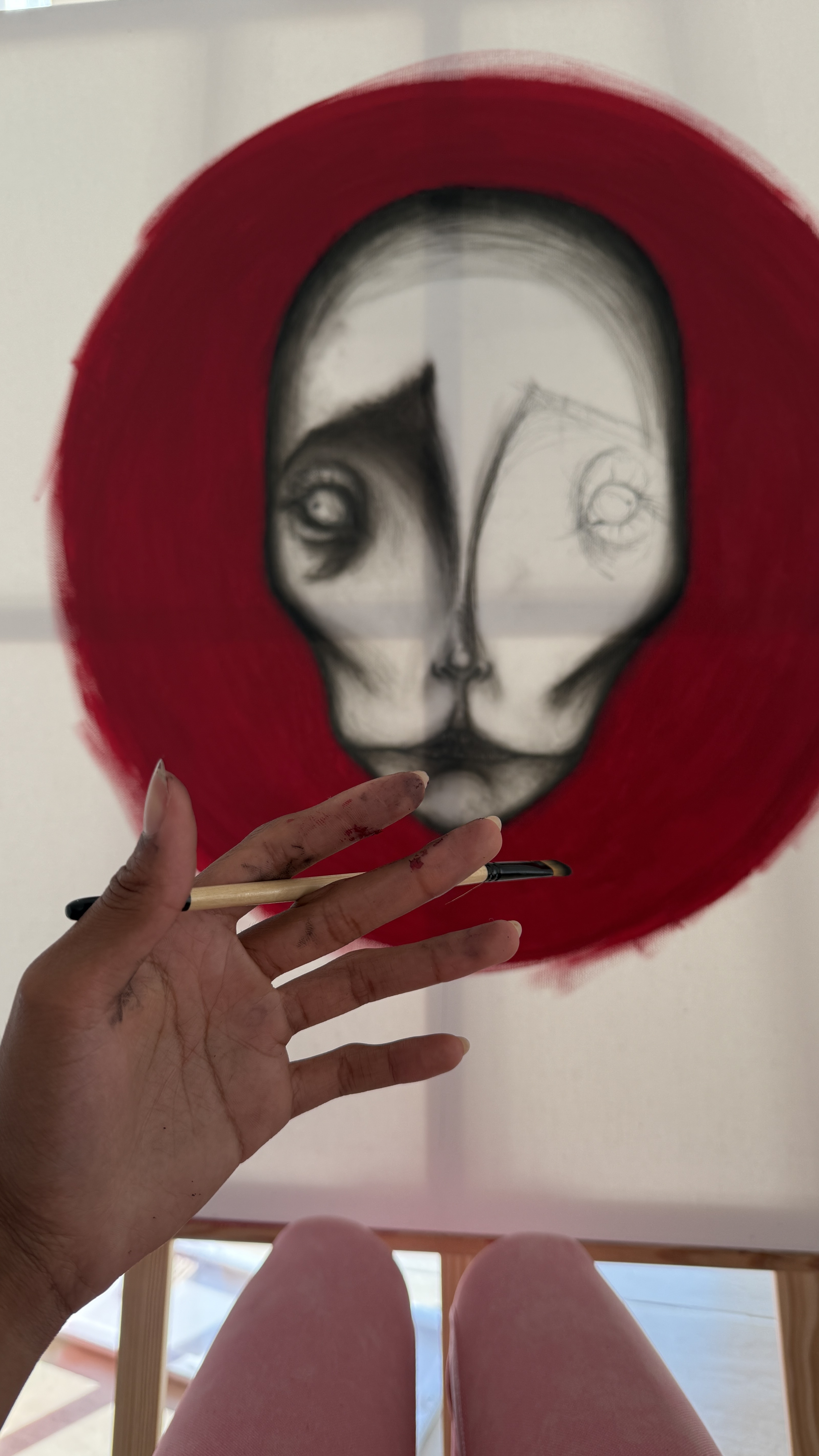 Christiana Klaasen painting a portrait inside a red circle on loose canvas