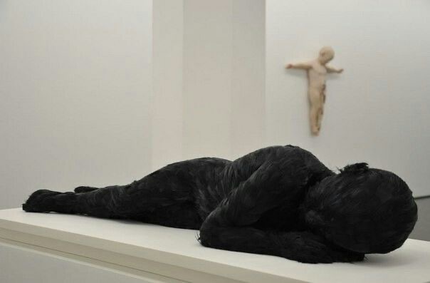 Lucy Glendinning Feather Child sculpture, a curled body covered in black feathers