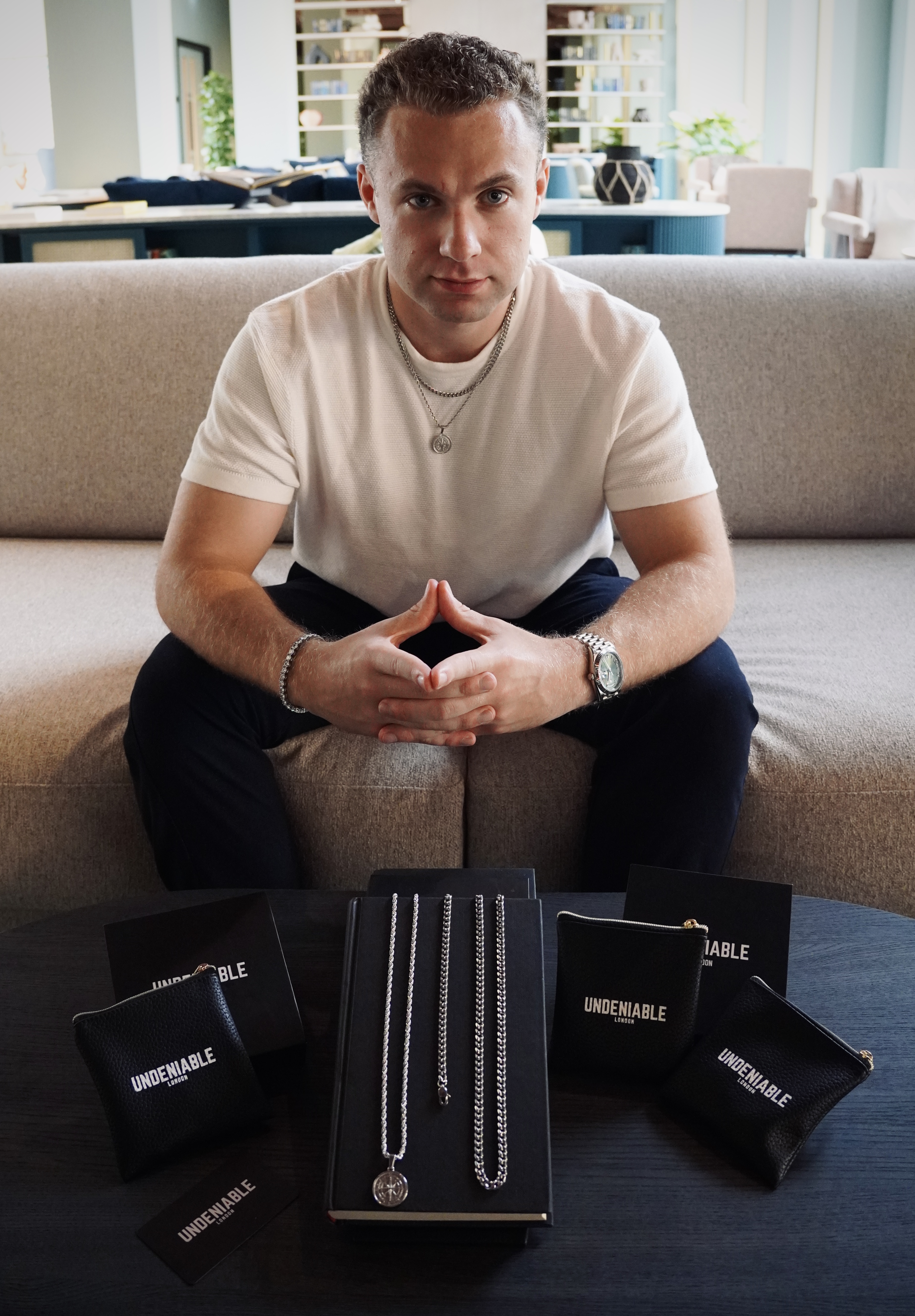 Founder seated behind an Undeniable London jewellery display