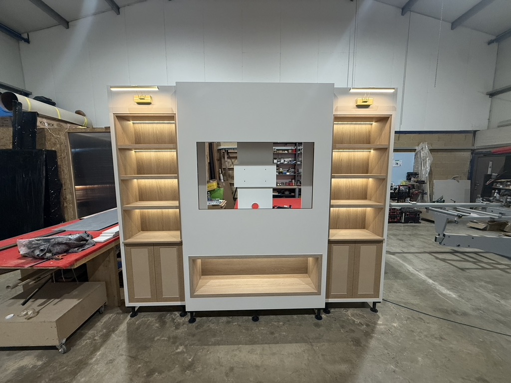 Workshop Build — Central TV niches flanked by lit shelving towers