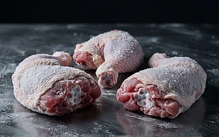 Frozen chicken portions on dark brushed steel