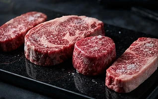 Premium raw beef cuts with frost on dark polished stone