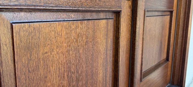 Close-up of restored double wooden entry doors with brass hardware