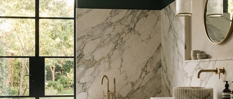 Luxury freestanding bathtub in a beautifully designed bathroom with herringbone floor tiles and brushed brass fixtures