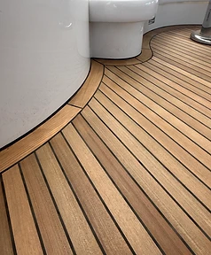 Curved teak deck margin board and new planks with clean black caulking lines