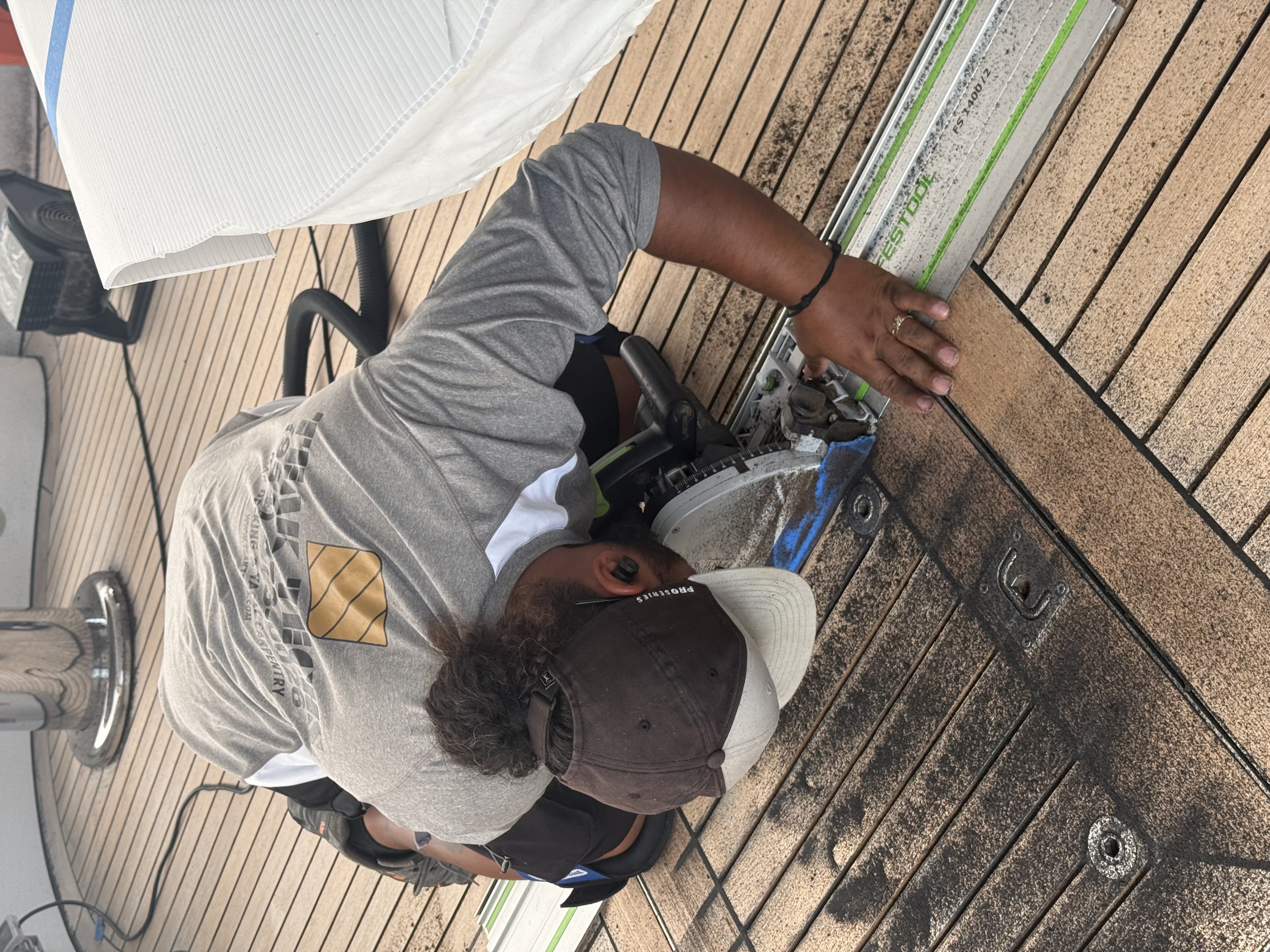 Teak Techs marine carpenter cutting a replacement teak plank with a track saw