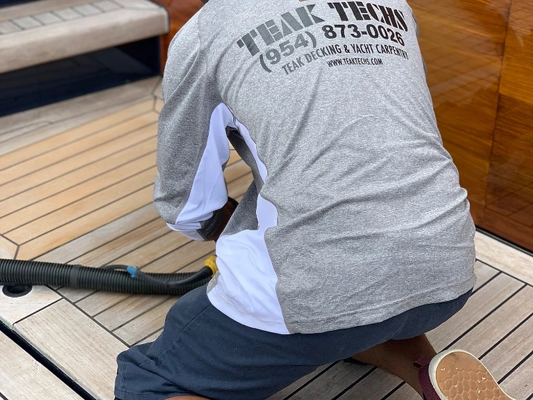 Teak Techs technician performing teak deck sanding and repairs on a Fort Lauderdale yacht