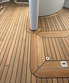 Teak deck panel fitted around a deck pedestal and flush hatch with matched seams