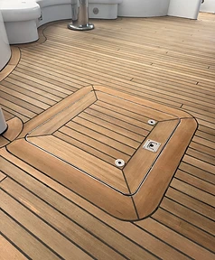 Teak deck with a flush hatch framed by mitered border planks and uniform seams
