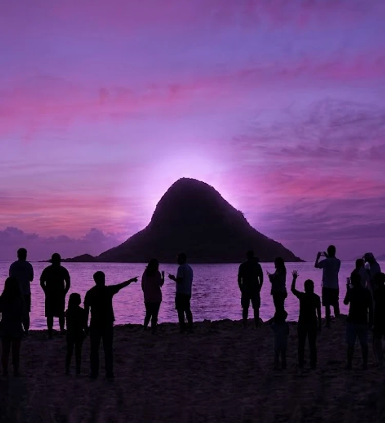 Silhouette of a group on a Hawaiian beach at twilight