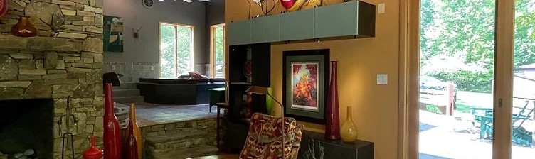 A stone fireplace and cozy lounge inside Camp Baer