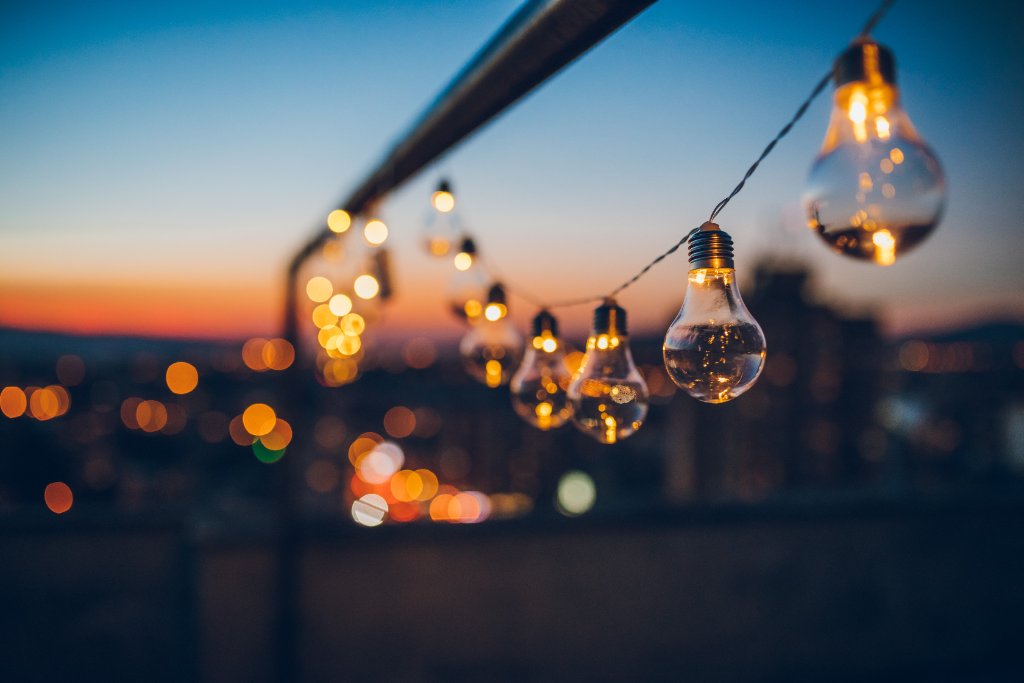 String of glowing Edison bulbs at dusk