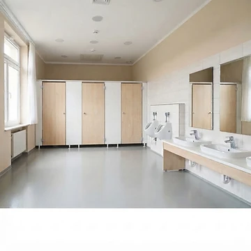 Gepflegter, hygienischer Kita-Sanitärraum mit Toilettenkabinen, zwei Urinalen und zwei Waschbecken