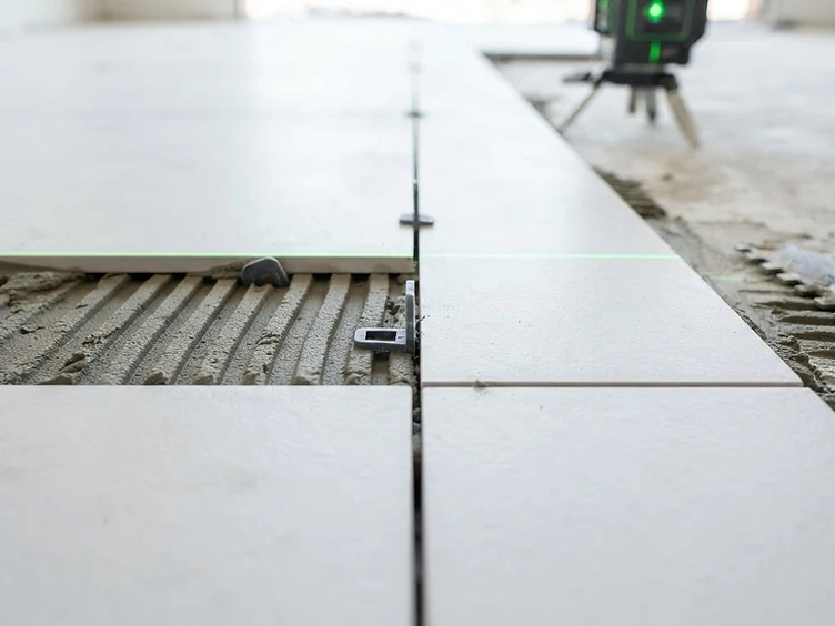 Macro detail of tile installation with laser level and perfect grout lines