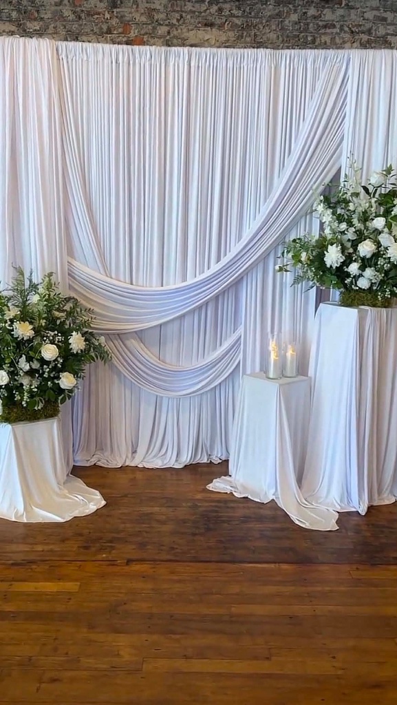Elegant white draped backdrop with florals