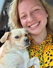 Chloe smiling holding a small dog