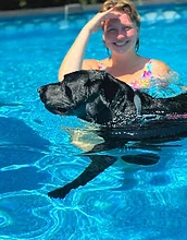 Chloe swimming with a black Labrador
